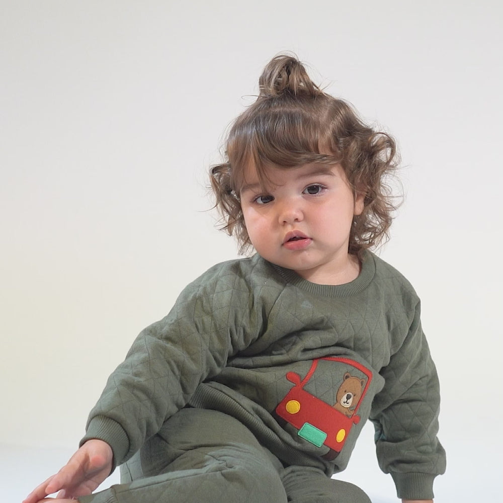 
                      
                        Load and play video in Gallery viewer, Baby in an olive-green quilted tracksuit with a red car and brown bear embroidery.
                      
                    